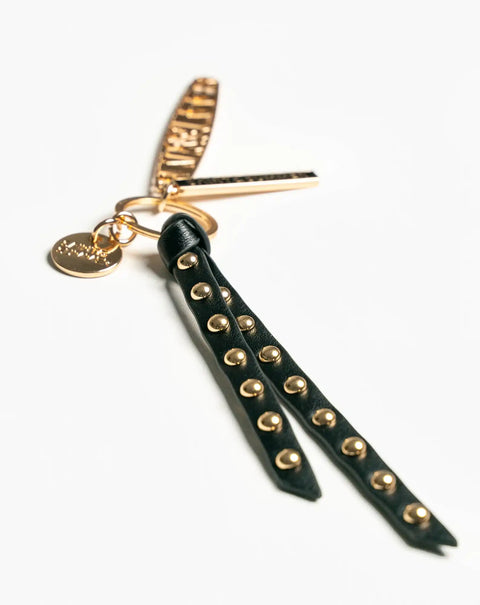 Black leather strap with gold studs attached to a keychain.