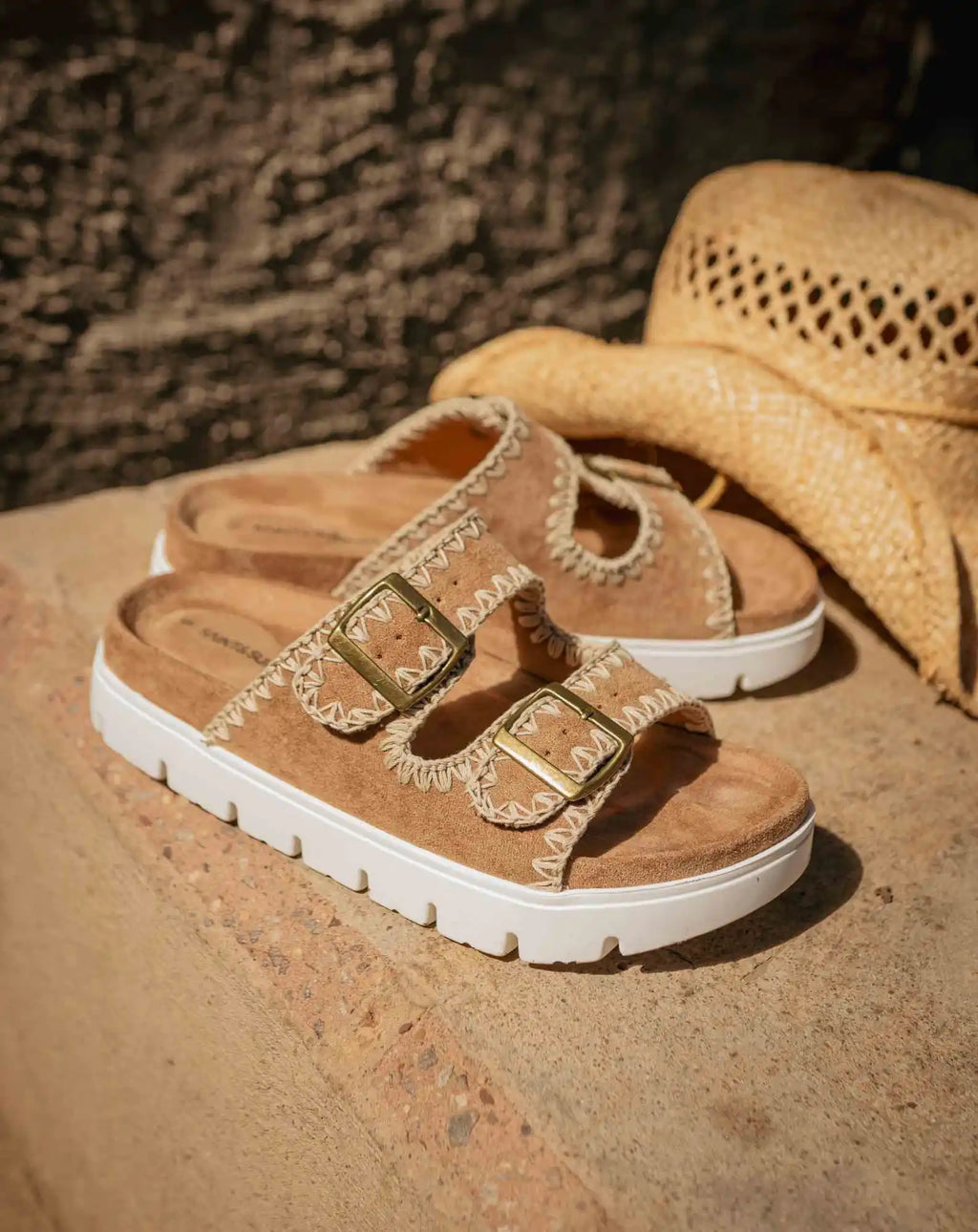 Gold metallic sandals with two buckle straps and chunky white soles.